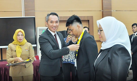 
					KEPALA Pusdiklat Manajemen & Kepemimpinan Mahkamah Agung, Syamsul Arief mengalungkan kokarde kepada perwakilan peserta Pelatihan Kompetensi PBJP Level-1 Angkatan II & III Tahun 2023, Senin-Rabu (21-23/8).